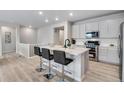 Modern kitchen with white cabinets, stainless steel appliances, and an island with seating at 13351 E 100Th Pl, Commerce City, CO 80022