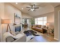 Spacious living room with a fireplace, hardwood floors, and large windows at 6475 Orion Way, Arvada, CO 80007