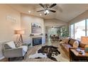 Spacious living room with a fireplace, hardwood floors, and large windows at 6475 Orion Way, Arvada, CO 80007