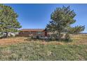 Brick ranch home with a red door and large yard at 2452 Shetland Trl, Elizabeth, CO 80107