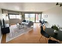 Bright living room with hardwood floors and city views at 100 Park Ave # 1208, Denver, CO 80205