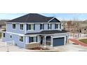Two-story home with light blue siding, navy blue shutters, and a two-car garage at 941 Saint Andrews Ln, Louisville, CO 80027