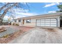 Brick Ranch home with attached garage and landscaping at 6563 Simms St, Arvada, CO 80004