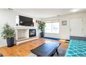 Living room with fireplace, hardwood floors, and large TV at 20000 Mitchell Pl # 71, Denver, CO 80249