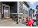 Inviting front porch with red chairs and stonework at 8938 Ferncrest St, Longmont, CO 80504