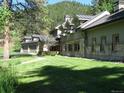 House exterior showcasing a stone and wood home with a large yard and mountain views at 7948 S Turkey Creek Rd, Morrison, CO 80465