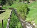 Property features a natural stream bordered by lush green vegetation at 7948 S Turkey Creek Rd, Morrison, CO 80465