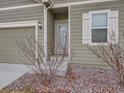 Front entrance of the house with steps, shrubs, and light fixtures at 7203 Arkansas St, Frederick, CO 80530