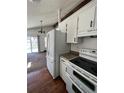 Kitchen with white appliances and wood flooring at 18064 E Ford Pl, Aurora, CO 80017