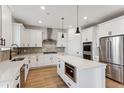 Modern kitchen with white cabinets, herringbone backsplash and island at 42972 Colonial Trl, Elizabeth, CO 80107