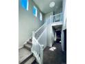 Bright entryway with a staircase featuring a white railing and gray carpeting at 19085 E 66Th Ave, Denver, CO 80249