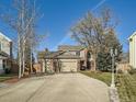 Two-story brick home with three-car garage and mature trees at 6579 Poppy St, Arvada, CO 80007