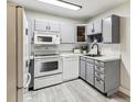 Modern kitchen with gray cabinets and white appliances at 9315 E Center Ave # 11A, Denver, CO 80247