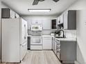 Modern kitchen with gray cabinets and white appliances at 9315 E Center Ave # 11A, Denver, CO 80247
