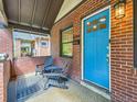 Cozy front porch with seating area, brick exterior at 1044 S Corona St, Denver, CO 80209