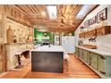 Rustic kitchen with an island, stone fireplace, and wood ceiling at 27150 Highway 74, Evergreen, CO 80439