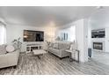 Spacious living room with gray couches, wood-look flooring, and a fireplace at 493 N 48Th Ave, Brighton, CO 80601