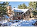 Two-story house with double garage, greenhouse, and snowy landscaping at 746 Bow Mountain Rd, Boulder, CO 80304