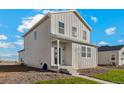 Side view of a two-story house with gray siding and a small front yard at 3003 Oxley St, Strasburg, CO 80136