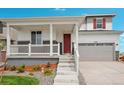 Two-story house with a covered porch, red door, and attached garage at 3292 N Highlands Creek Pkwy, Aurora, CO 80019