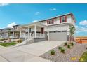 Two-story house with a covered porch, red door and attached garage at 3292 N Highlands Creek Pkwy, Aurora, CO 80019