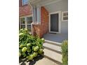 Brick building entrance with dark gray door and landscaping at 22975 E Ontario Dr # 101, Aurora, CO 80016