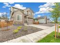 Two-story house with gray siding, a two-car garage, and landscaping at 9374 Bahama Ct, Commerce City, CO 80022