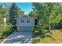 Two-story home with gray siding, a two-car garage and a large yard at 6034 S Niagara Ct, Centennial, CO 80111