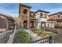 Two story home with walkway and landscaping, and black metal fence at 4553 Osceola St, Denver, CO 80212