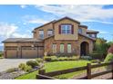 Two-story home with stone and stucco exterior, three car garage, and landscaping at 7592 Lupine Ct, Arvada, CO 80007