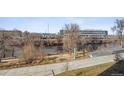 Tranquil riverfront scene with walking path and cityscape in distance at 3575 Chestnut Pl # 606, Denver, CO 80216