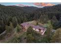 Luxury home nestled in a wooded, mountainous area with stunning sunset views at 22759 Mountain Spirit Way, Indian Hills, CO 80454