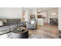 Open living room with gray couch, recliner, and coffee table, hardwood floors at 15700 E Jamison Dr # 8-103, Englewood, CO 80112