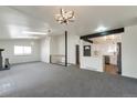 Open living area with a fireplace, skylights, and views into the kitchen at 3754 S Mission Pkwy, Aurora, CO 80013