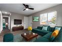 Living room with green sectional sofa and mid-century modern decor at 6971 Newport St, Commerce City, CO 80022