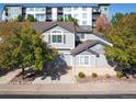 Townhouse exterior view with gray siding, brick accents, and a two-car garage at 1355 S Ulster St, Denver, CO 80231