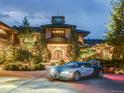 Luxury home exterior with a grand entrance and circular driveway at night at 24503 Chris Dr, Evergreen, CO 80439