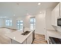 Modern kitchen with white cabinets, quartz countertops, and stainless steel appliances at 12853 Range St, Firestone, CO 80107