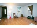 Living room with hardwood floors, large windows, and a view to the front door at 7261 Magnolia St, Commerce City, CO 80022