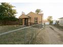 A beige ranch house with a gravel driveway and chain link fence at 7261 Magnolia St, Commerce City, CO 80022