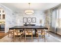 Elegant dining room with a modern dark wood table, stylish chairs, and unique cloud-themed wallpaper at 2565 S Milwaukee St, Denver, CO 80210