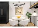 Modern dining area with a round table and four white chairs at 3429 Lawrence St, Denver, CO 80205