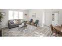 Living room with grey sofa, coffee table, area rug, and access to a hallway at 1192 S Zeno Way # H, Aurora, CO 80017