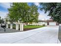 Ranch home with a large yard, detached garage, and long driveway at 1000 S Geneva St, Aurora, CO 80247