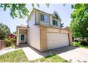 Two-story house with beige siding, brick accents, and a two-car garage at 4144 Dunkirk Ct, Denver, CO 80249