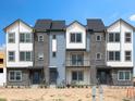 Three-story townhome with modern design, gray and white siding at 14412 Pansy Loop, Morrison, CO 80465