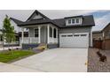 Two-story house with gray siding, white porch, and landscaped yard at 1906 Spotted Owl Ct, Brighton, CO 80601