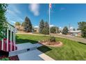 Landscaped front yard with a well-maintained lawn and flower bed at 9350 Grandview Ave, Arvada, CO 80002