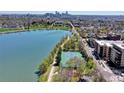 Aerial view showcasing a tennis court and a lake, with a city skyline in the background at 4200 W 17Th Ave # 235, Denver, CO 80204