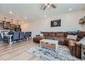 Spacious living room with L-shaped sectional sofa, hardwood floors, and kitchen views at 16433 Askins Loop, Parker, CO 80134